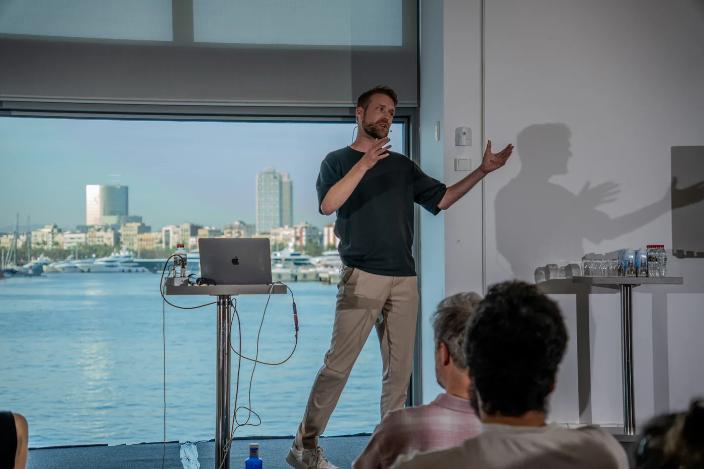 Jasper on stage at the Claude Community Event in Barcelona, the harbour behind him